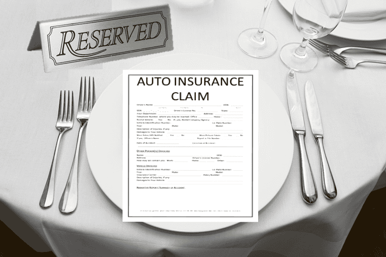 A "Reserved" sign on a restaurant table with an auto insurance claim form placed on the plate, surrounded by standard table settings including forks, knives, and wine glasses.