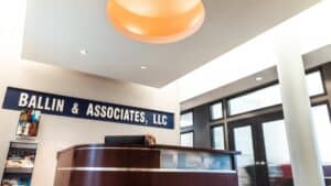 Reception area of Ballin & Associates, LLC featuring a modern desk, magazine rack, and signage.
