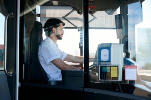 Bus driver seated at steering wheel inside public transit vehicle