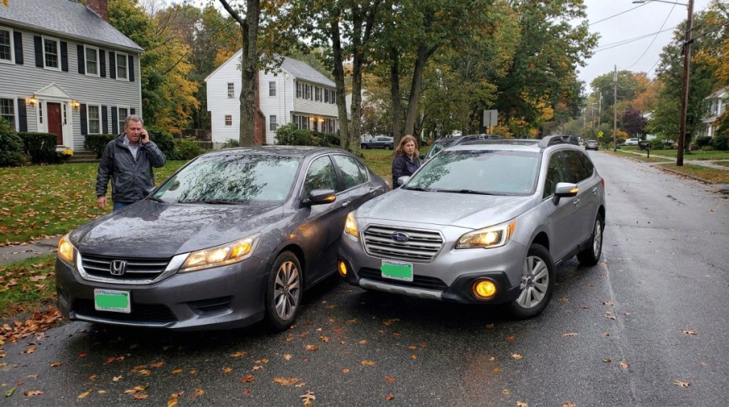two vehicles involved in rear-end collision on residential street with drivers outside